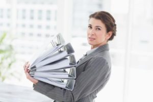 a businesswoman holding a stack of files